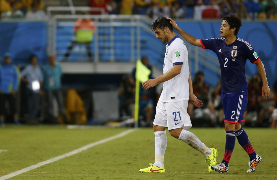 Greece's Kostas Katsouranis (L) is consoled by Japan's Atsuto Uchida after Katsouranis is sent off the field with a red card during their 2014 World Cup Group C soccer match at the Dunas arena in Natal June 19, 2014. REUTERS/Kai Pfaffenbach