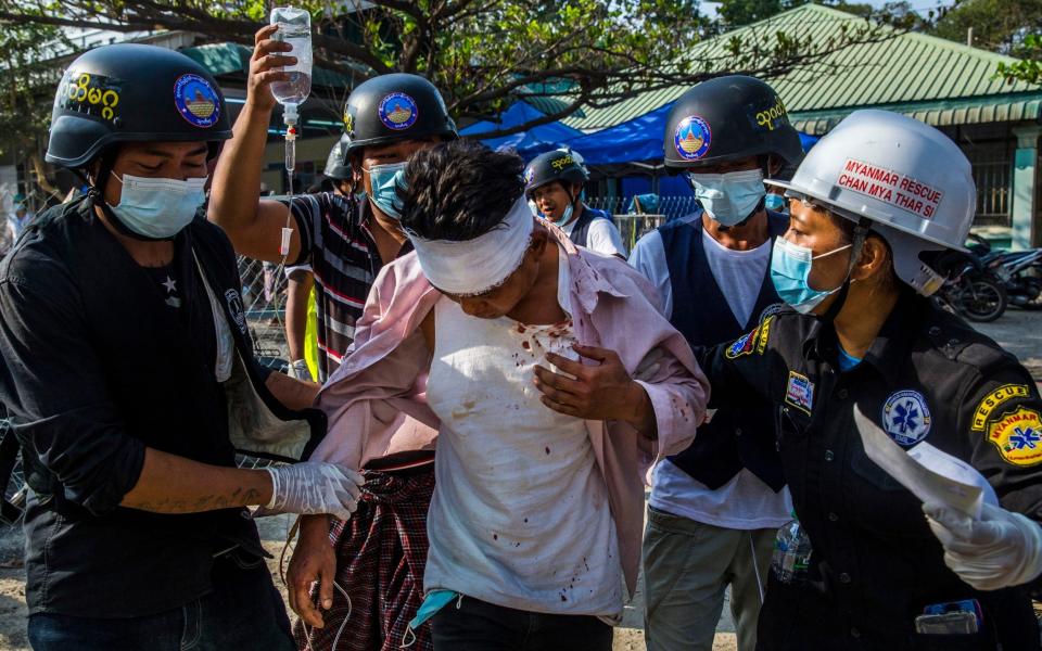 An injured protester receives medical attention after police and military forces cracked down on a protest  - THE NEW YORK TIMES 