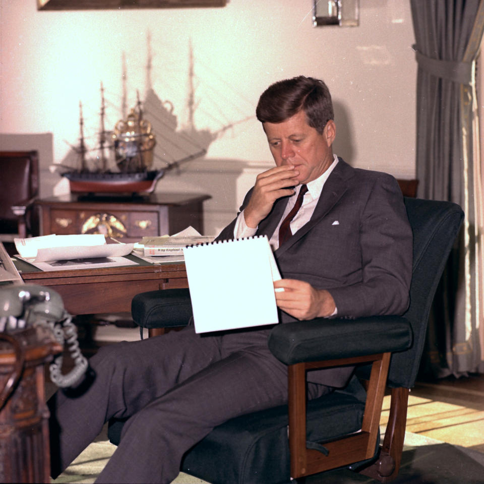 FILE - In this Jan. 18, 1962 file photo, U.S. President John F. Kennedy looks over notes at his desk in the White House. (AP Photo/Henry Burroughs)