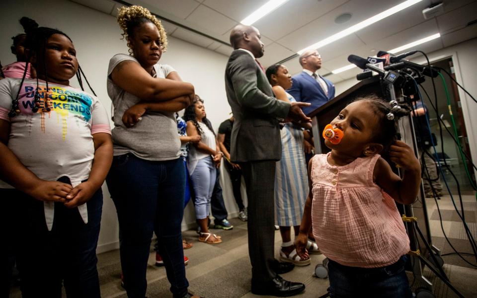 Blessen Miller, 8, left, and her sister, Memory, 2, right, daughters of Tomika Miller, second left, widow of Rayshard Brooks, are seen at a news conference held by members of the Brooks' family  - AP