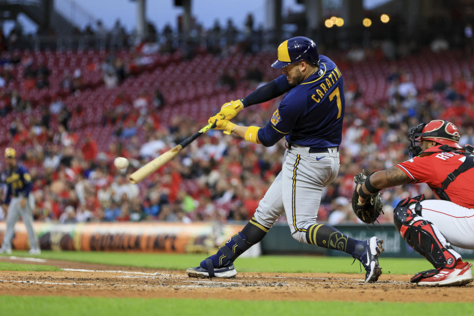 Milwaukee Brewers' Victor Caratini hits a double during the second inning of a baseball game against the Cincinnati Reds in Cincinnati, Friday, Sept. 23, 2022. Brewers' Andrew McCutchen and Luis Urias scored runs on a throwing error by Reds' Aristides Aquino. (AP Photo/Aaron Doster)