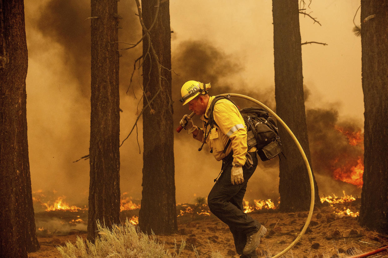 A firefighter battles the Caldor Fire along Highway 89, Tuesday, Aug. 31, 2021, near South Lake Tahoe, Calif. (AP Photo/Noah Berger)