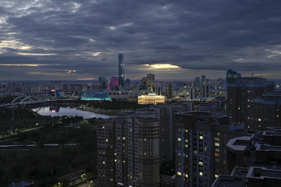 FILE - A night view of the capital Astana, Kazakhstan, with the Presidential Palace seen in the center, Monday, Sept. 12, 2022. The trial of businessman Kuandyk Bishimbayev, Kazakhstan's former economy minister, in the death of his wife, Saltanat Nukenova, has touched a nerve in the Central Asian country. Tens of thousands of people have signed petitions calling for harsher penalties for domestic violence. On April 11, senators approved a bill toughening punishment for spousal abuse, and President Kassym-Jomart Tokayev signed it into law four days later. (AP Photo/Alexander Zemlianichenko, File)