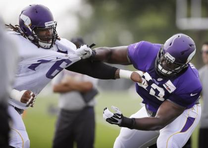 Isame Faciane, left, in Vikings training camp, 2014 (AP Photo/Charlie Neibergall).