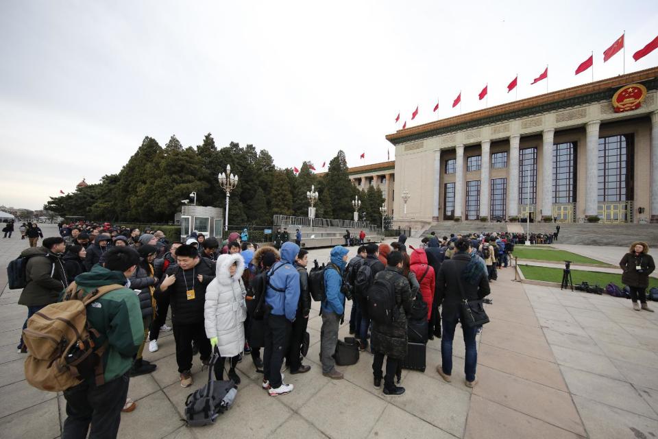 Local and foreign journalists line up to enter the Great Hall of the People to cover the opening session of the annual National People's Congress in Beijing, Sunday, March 5, 2017. China's top leadership as well as thousands of delegates from around the country are gathered at the Chinese capital for the annual legislature meetings. (AP Photo/Andy Wong)
