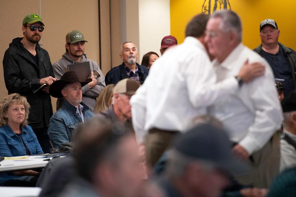 Bidders react to a bidding war during an auction in Eaton, Colo., on Tuesday, Feb. 28, 2024.