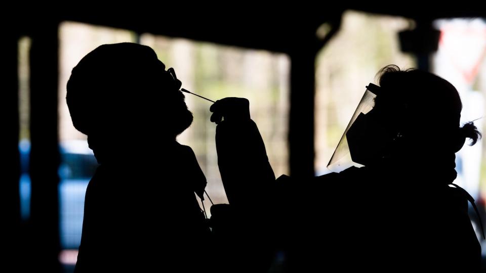 Helfer testen einen Mann im «Testzentrum am Zoo» in Hannover mit einem Schnelltest auf das Coronavirus.