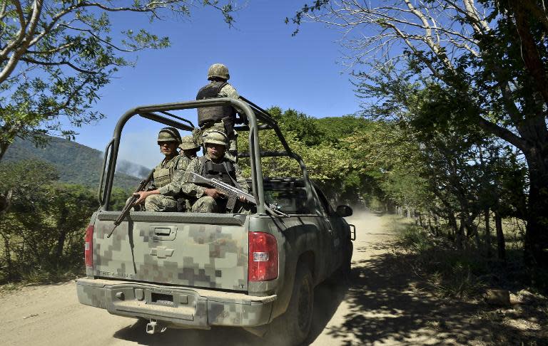 Soldiers of the 88th infantry brigade patrol the area around the site where a military helicopter was shot down two days ago, in Villa Vieja community, Jalisco State, Mexico, on May 3, 2015