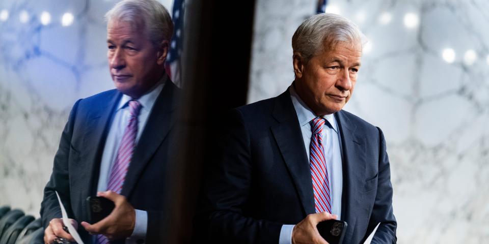 A man is seen in a government building beside his reflection.