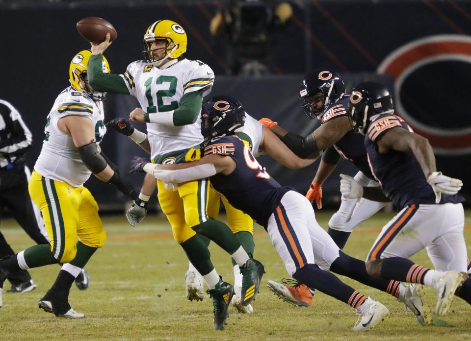 Green Bay Packers quarterback Aaron Rodgers passes the ball under pressure from Chicago Bears linebacker Trevis Gipson.