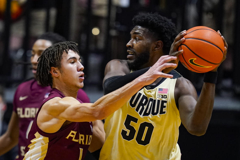 Purdue forward Trevion Williams (50) makes a pass over Florida State guard Jalen Warley (1) during the first half of an NCAA college basketball game in West Lafayette, Ind., Tuesday, Nov. 30, 2021. (AP Photo/Michael Conroy)