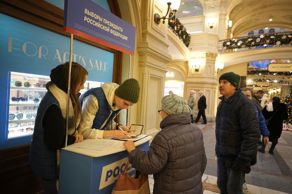 Putin's United Russia party's volunteers sign people for the election. (AP)