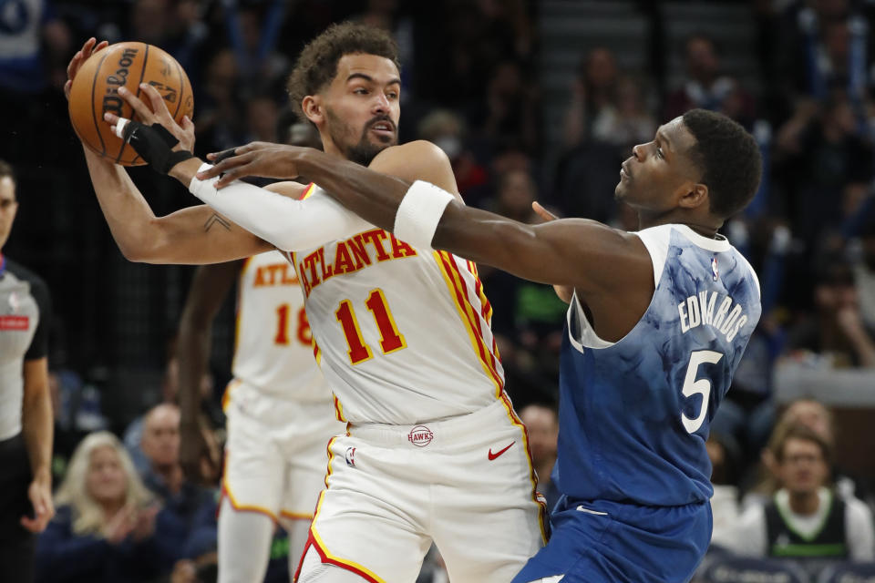 Atlanta Hawks guard Trae Young (11) works to keep the ball away from Minnesota Timberwolves guard Anthony Edwards (5) during the first quarter of an NBA basketball game Friday, April 12, 2024, in Minneapolis. (AP Photo/Bruce Kluckhohn)
