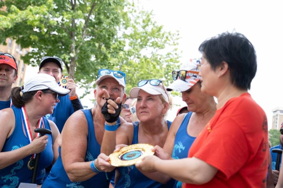 SLAP Dragons team members accept their award for placing first in the races at the 35th annual Kansas City Dragon Boat Festival.