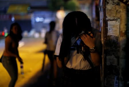 A woman reacts after tear gas was fired by the police near Yuen Long station, in Hong Kong