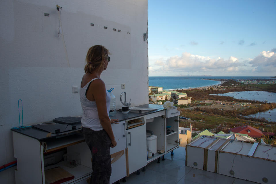 <p>A photo taken on September 17, 2017 shows a woman standing in a room without a roof or windows at the Alizea residence in Mont Vernon, on the French Caribbean island of Saint Martin, after the passage of Hurricane Irma. (Photo: Helene Valenzuela/AFP/Getty Images) </p>