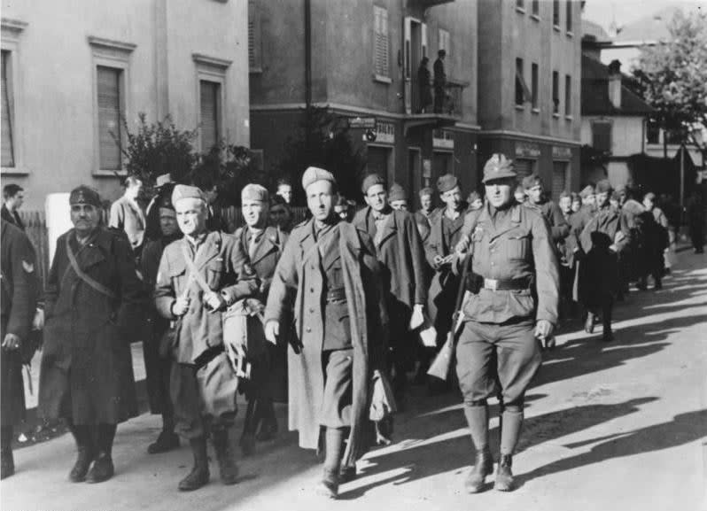 A Nazi propaganda photograph, showing German soldiers escorting disarmed Italian troops through the Italian city of Bolzano during World War II. <em>German Federal Archives</em>