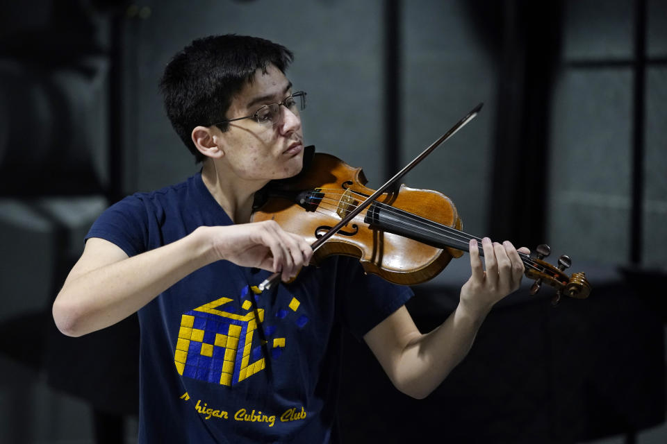 University of Michigan student Stanley Chapel performs one of Johann Sebastian Bach's violin sonatas from memory, Wednesday, Nov. 23, 2022, in Ann Arbor, Mich. Stanley is one of the world's foremost "speedcubers," a person capable of quickly solving a Rubik's Cube and is also an accomplished violinist. Chapel says the two fields aren't as different as one might think. Chapel has certain inherent abilities -- he is capable of remembering and applying thousands of algorithms to solve a Rubik's Cube and (AP Photo/Carlos Osorio)