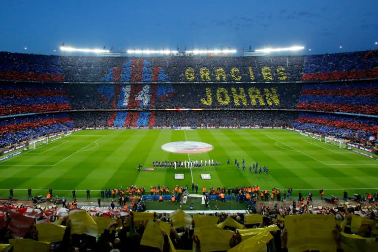 Football supporters hold-up posters to form a giant mosaic reading, "Thankyou Johan", in tribute to late Dutch football player Johan Cruyff before the Spanish league "Clasico" football match FC Barcelona vs Real Madrid CF on April 2, 2016