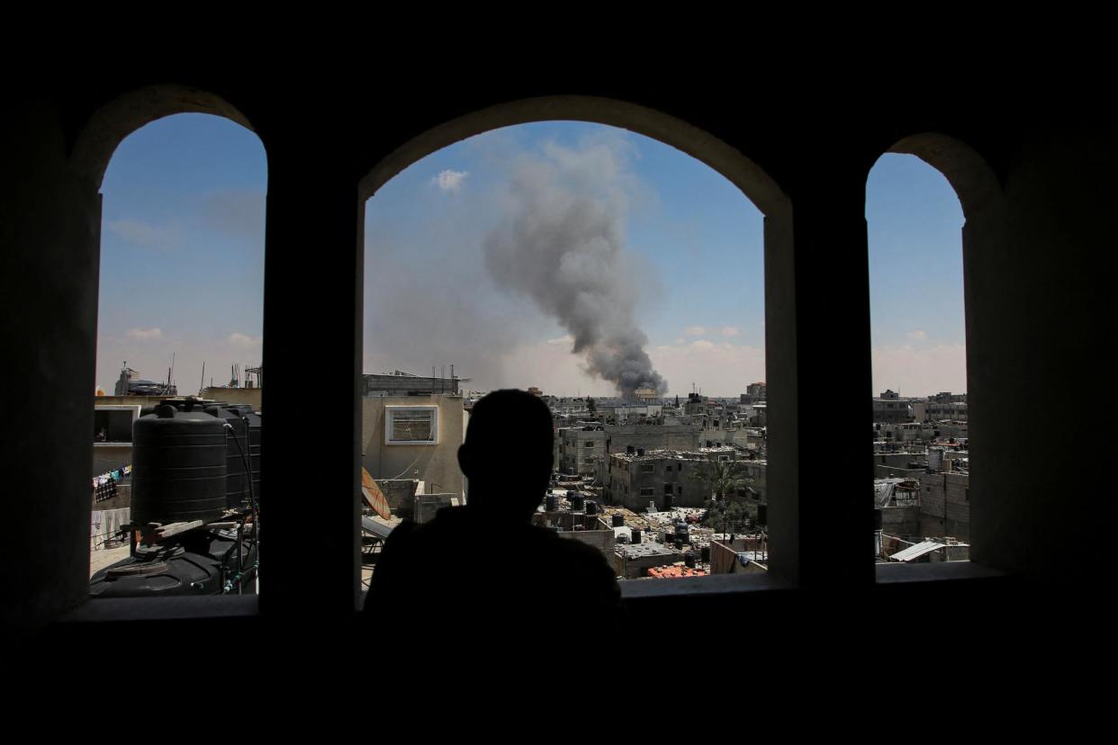 <span>A Palestinian man watches as smoke rises from an Israeli strike on Rafah on 7 May 2024.</span><span>Photograph: Hatem Khaled/Reuters</span>