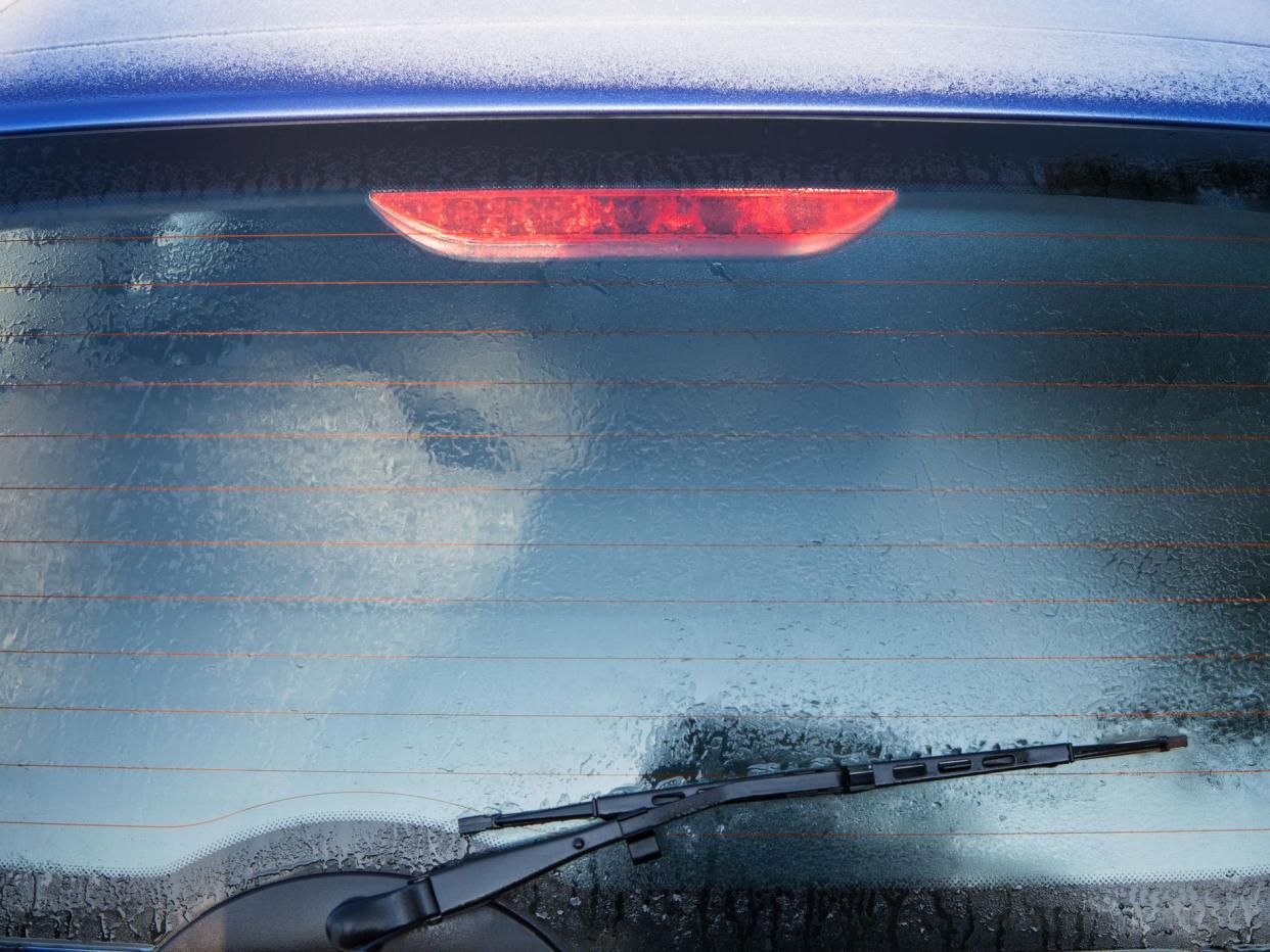 Frozen rear window of the car is covered with ice