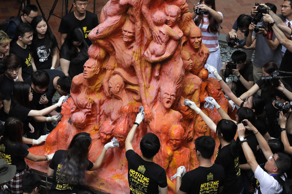 FILE - In this June 4, 2019, file photo, university students clean the "Pillar of Shame" statue, a memorial for those killed in the 1989 Tiananmen crackdown, at the University of Hong Kong. Danish artist Jens Galschioet is seeking to get back his sculpture in Hong Kong memorializing the victims of China's 1989 Tiananmen Square crackdown as a deadline loomed for its removal Wednesday, Oct. 13, 2021. (AP Photo/Kin Cheung)