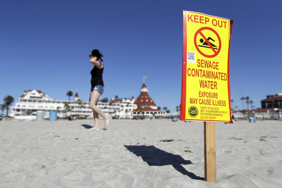 A sign warns of sewage contaminated ocean waters on a beach in front of the iconic Hotel del Coronado on Wednesday, March 1, 2017, in Coronado, Calif. Coronado and Imperial Beach waters remain closed to swimmers and surfers Wednesday after more than 140 million gallons of raw sewage spilled into the Tijuana River in Mexico and flowed north of the border for weeks in February, according to a report. (AP Photo/Gregory Bull)