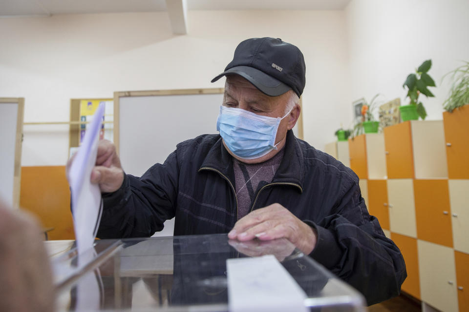 A man casts his ballot during parliamentary elections in the town of Bankya near capital Sofia, Bulgaria on Sunday, April 4, 2021. Bulgarians are heading to the polls on Sunday to cast ballots for a new parliament after months of anti-government protests and amid a surge of coronavirus infections. (AP Photo/Visar Kryeziu)