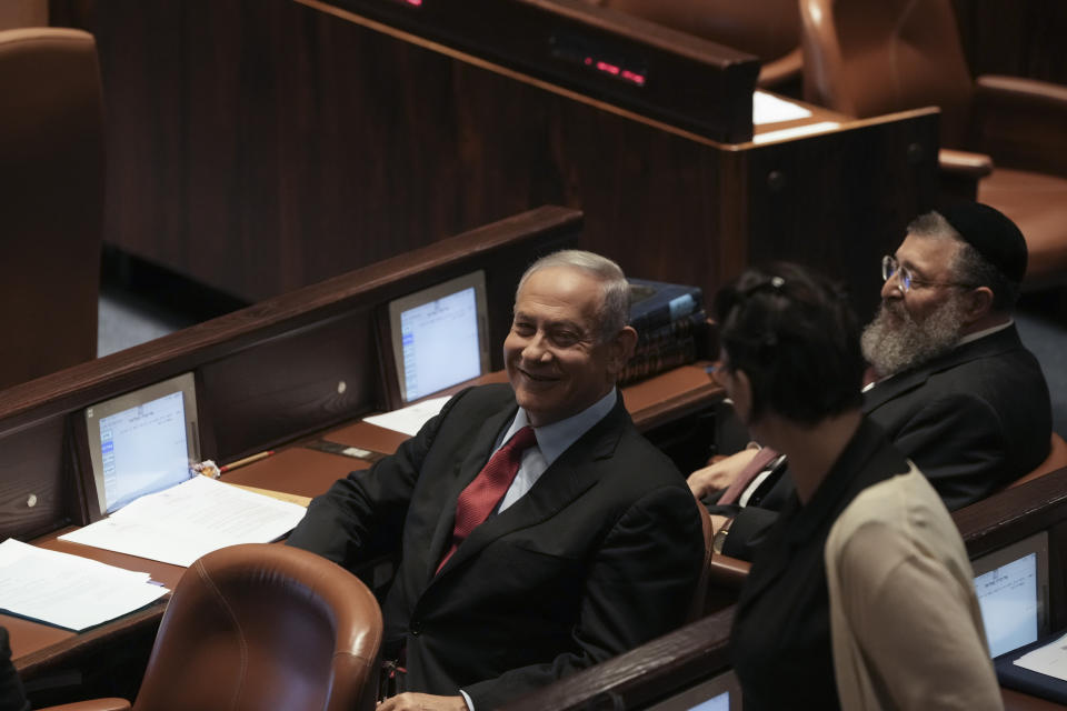 Former Israeli Prime Minister Benjamin Netanyahu smiles during a preliminary vote on a bill to dissolve parliament, at the Knesset, Israel's parliament, in Jerusalem, Wednesday, June 22, 2022. Israeli lawmakers voted in favor of dissolving parliament in a preliminary vote, setting the wheels in motion to send the country to its fifth national election in just over three years. (AP Photo/Maya Alleruzzo)