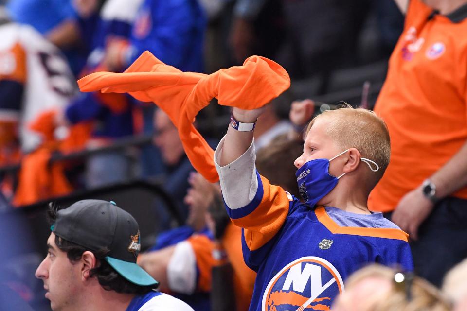 New York Islanders fans cheer in the game against the Pittsburgh Penguins during the third period in Game 6 of the first round of the 2021 Stanley Cup Playoffs at Nassau Veterans Memorial Coliseum.
