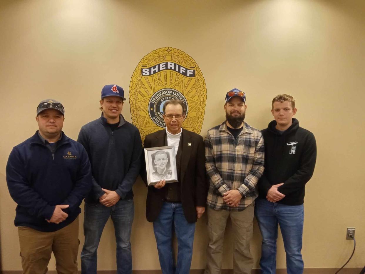 Don Hendrix, the father of the late Henderson County Sheriff's Deputy Ryan Hendrix, holds his son's photo on Feb. 1 at the Henderson County Sheriff's Office as he stands alongside his other sons (from left): Jeff, Jamin, Donald and Stephen.