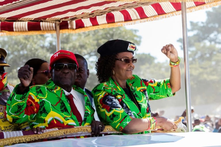 Zimbabwe President Robert Mugabe (L) with his wife Grace raise their fists before meeting delegates during a Zimbabwe ruling party ZANU-PF youth rally at Rudhaka Stadium in Marondera on June 2, 2017