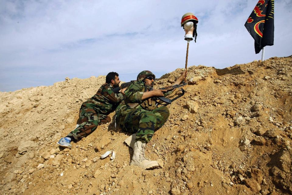 FILE - This Friday, Nov. 22, 2013 file photo, Iraqi and Lebanese Shiite fighters from a group called the Hussein Brigade use a helmet to draw a sniper into view during clashes between the Sunni-dominated Free Syrian Army and Syrian soldiers loyal to Syria's President Bashar Assad, supported by Iraqi and Lebanese Shiite fighters, in the town of Hejeira, which Syrian troops captured, in the countryside of Damascus, Syria. Aleppo is set to be recaptured by Syrian President Bashar Assad, but the victory will not be Assad's alone. The battle for Syria's largest city has attracted thousands of foreign forces, including Russian soldiers and thousands of fighters from Iran, Lebanon, Iraq and Afghanistan. (AP Photo/Jaber al-Helo, File)