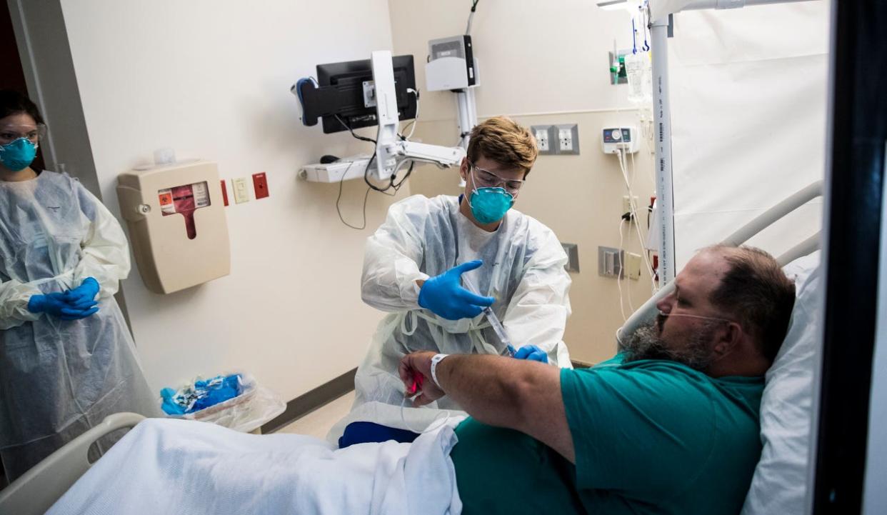Matthew Josephson, a registered nurse at Gulf Coast Medical Center in Fort Myers, treats Aaron Renfroe for symptoms associated with COVID-19 on Friday, Aug. 13, 2021.