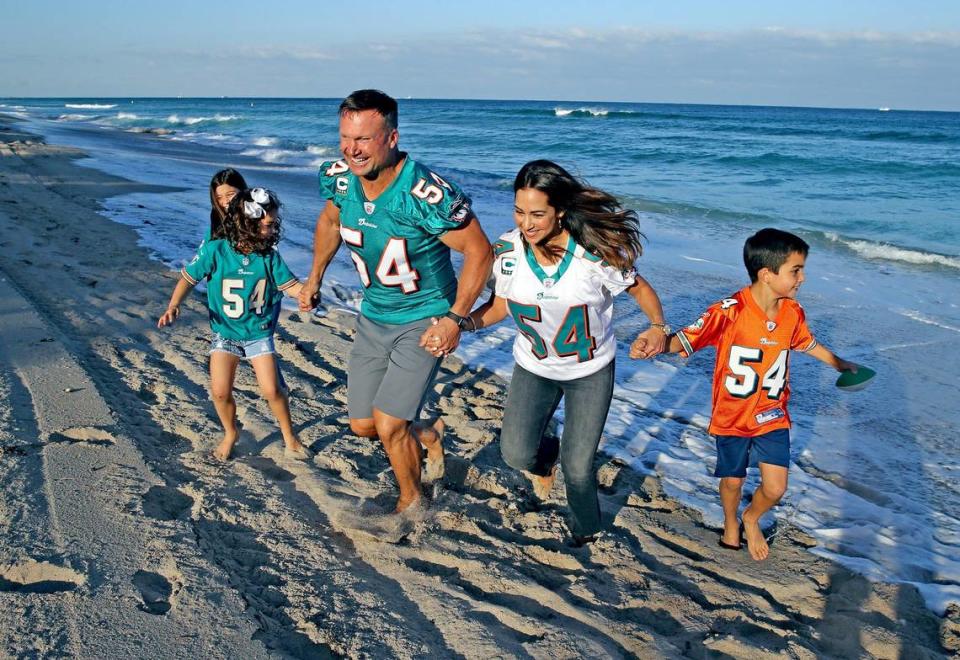 Former Miami Dolphins linebacker Zach Thomas runs on the beach with his wife Maritza and their kids Valentina 8, Sienna 4, and Christian 10, at their home in Hillsborough Beach, Florida, Tuesday, January, 21, 2020.