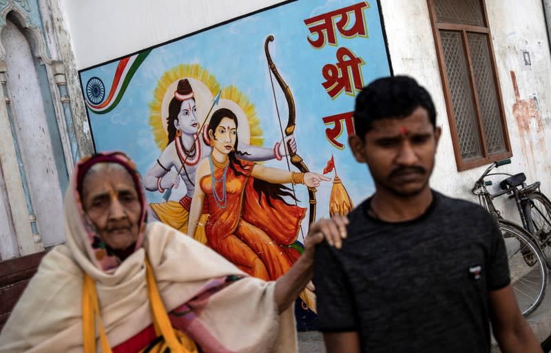 Devotees walk past a painting of Hindu god Rama and his wife Sita outside a temple in Ayodhya