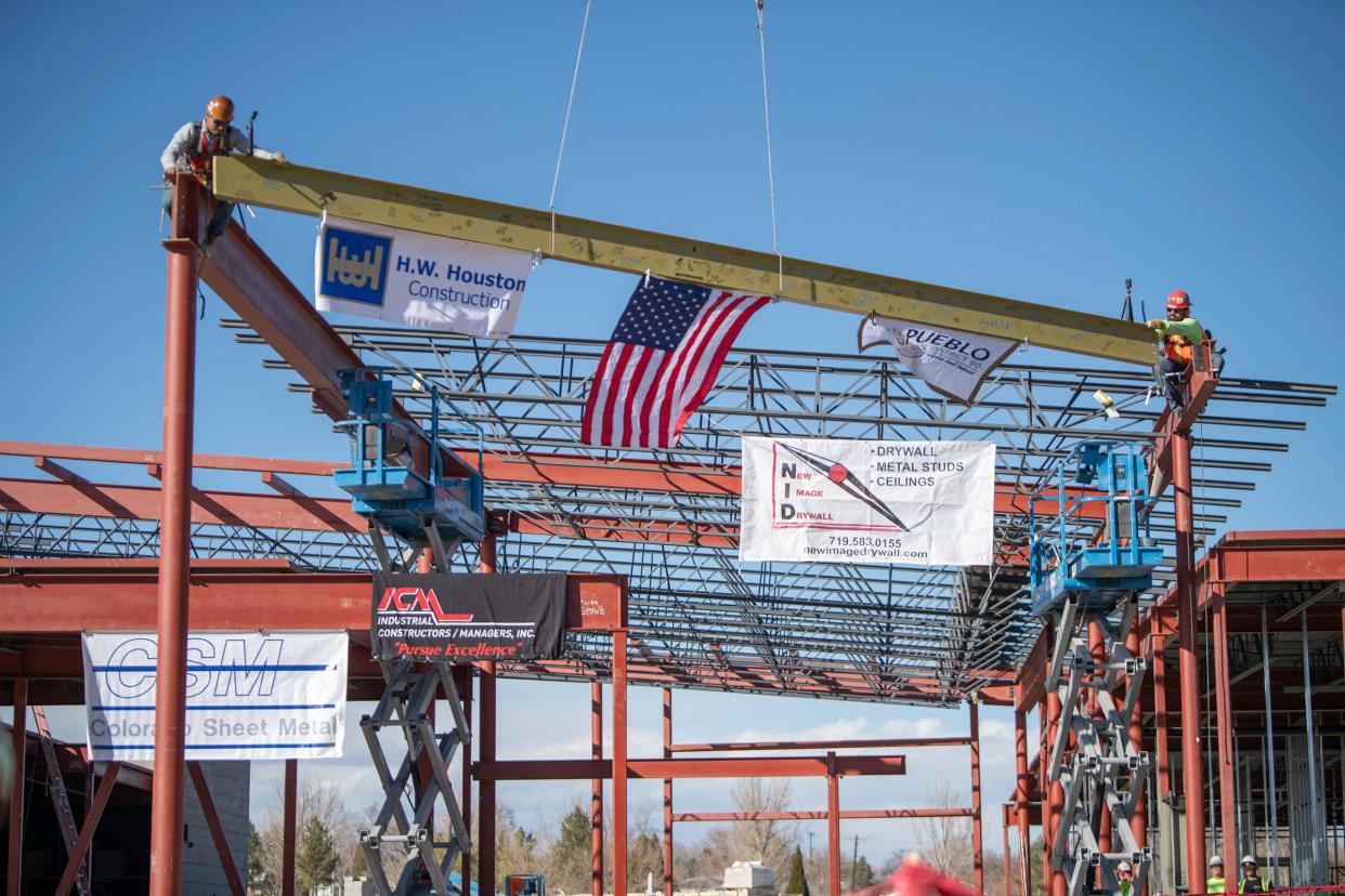 A construction crew guide a steel beam to complete the "topping out" ceremony at the Nettie S. Freed K-8 Expeditionary School on Tuesday, Dec. 6, 2022.