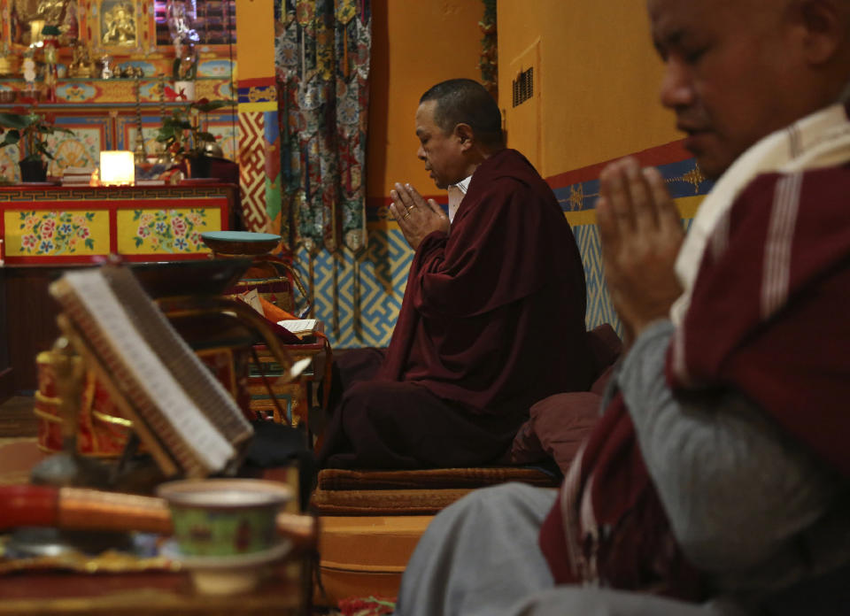 Lama Gelbu, left, and Pasang Sherpa, right, partake in the traditional Buddhist Dakini Day practice, a group meditation that includes song and food and is celebrated on the 25th day of each lunar month, at the United Sherpa Association in the Queens borough of New York on Friday, Jan. 8, 2021. (AP Photo/Jessie Wardarski)