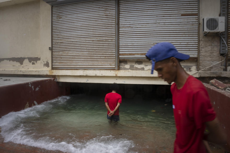 A man looks at the entrance of a parking garage at a street flooded by the waves that break on the Malecon in the aftermath of Hurricane Ian in Havana, Cuba, Thursday, Sept. 29, 2022. (AP Photo/Ramon Espinosa)