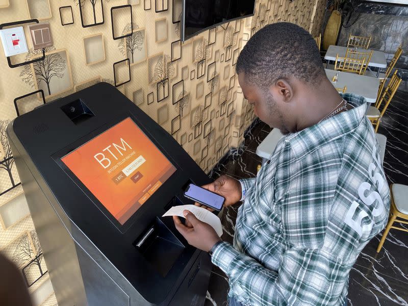 A bitcoin user checks the receipts after buying bitcoins with naira on Bitcoin Teller Machine in Lagos