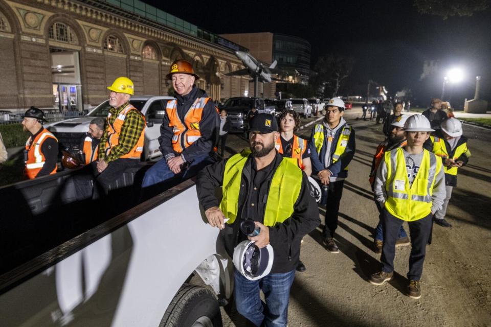 Crew members watch as the space shuttle Endeavour is placed into position.