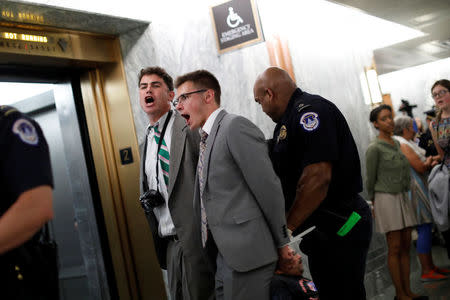 Capitol Police detain demonstrators as the Senate Finance Committee holds a hearing on the latest Republican Effort to repeal and replace the Affordable Care Act on Capitol Hill in Washington, U.S. September 25, 2017. REUTERS/Aaron P. Bernstein