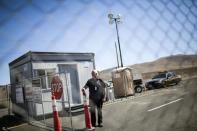 Security officer Cliff Romine stands at the gate to the future home of Tesla at the Tahoe-Reno Industrial Center in McCarran, Nevada, September 16, 2014. REUTERS/Max Whittaker