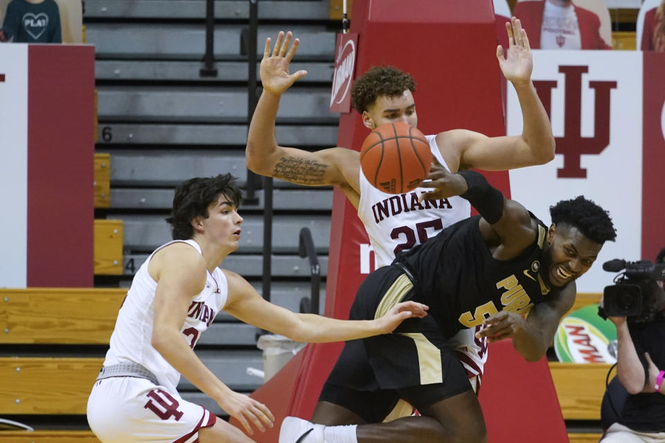 Purdue's Trevion Williams (50) passes the ball away from Indiana's Race Thompson (25) and Trey Galloway (32) during the second half of an NCAA college basketball game Thursday, Jan. 14, 2021, in Bloomington, Ind. Purdue won 81-69. (AP Photo/Darron Cummings)