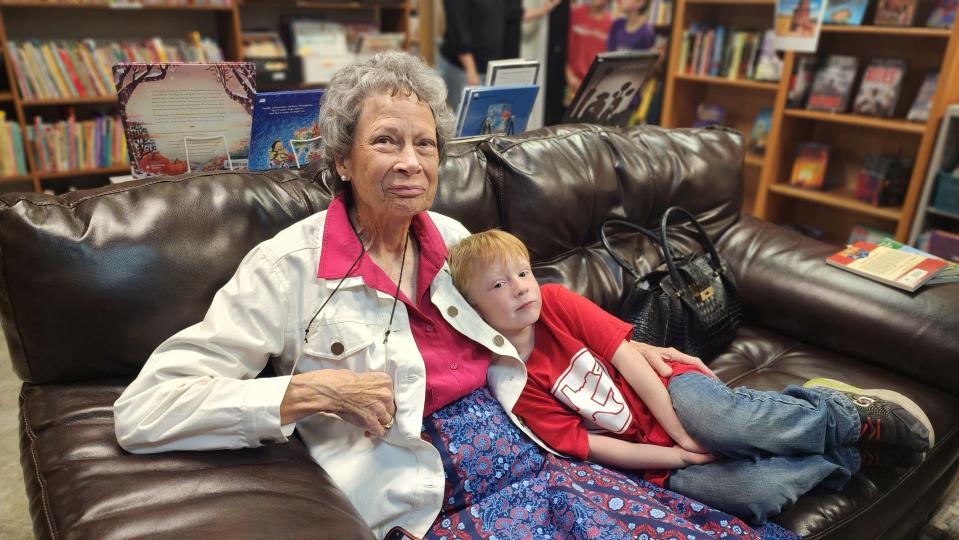 Kris Erickson, wife of "Hank the Cow Dog" author John Erickson, sits with a fan Thursday at the Burrowing Owl Books store in Amarillo.