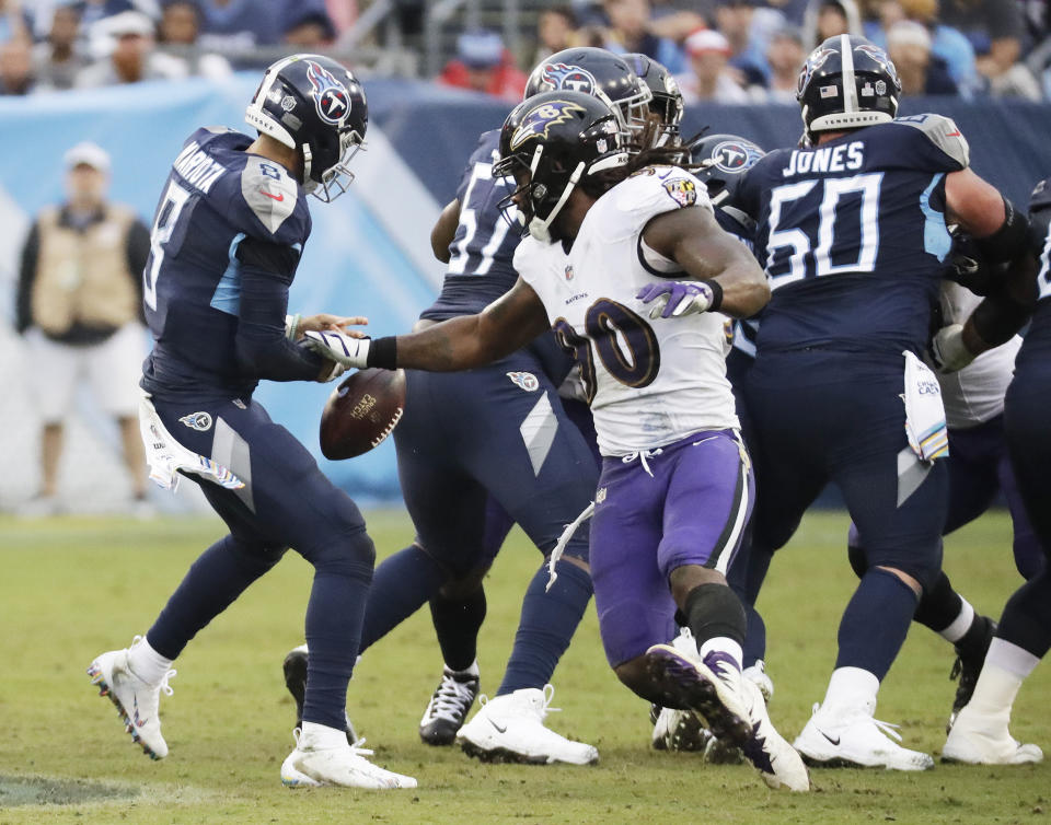 Baltimore Ravens linebacker Za'Darius Smith (90) knocks the ball loose from Tennessee Titans quarterback Marcus Mariota (8) in the first half of an NFL football game Sunday, Oct. 14, 2018, in Nashville, Tenn. Mariota recovered the ball on the play. (AP Photo/James Kenney)