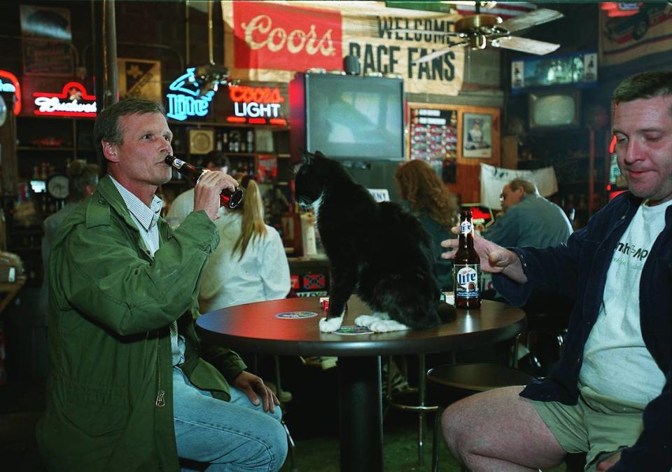 In this 2001 file photo, regulars at Puckett’s Farm Equipment socialize and make room for owner Gary Puckett’s cat, Blackie. Puckett is planning to close the business next March.