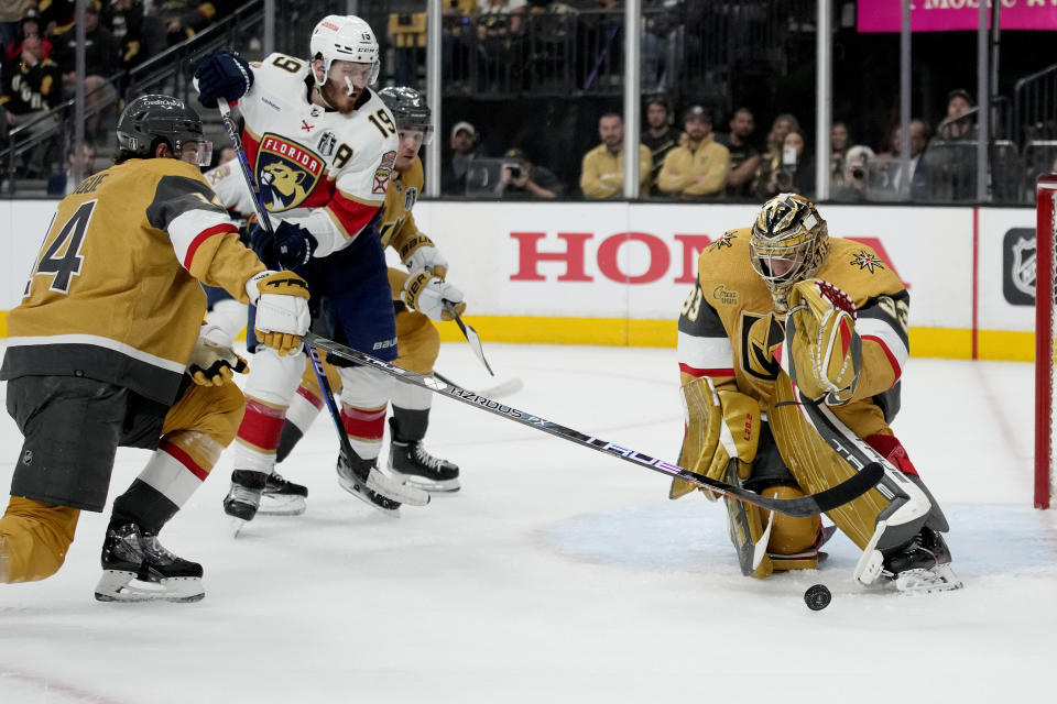 Vegas Golden Knights goaltender Adin Hill, right, stops a shot on goal by Florida Panthers left wing Matthew Tkachuk (19) during the first period of Game 2 of the NHL hockey Stanley Cup Finals, Monday, June 5, 2023, in Las Vegas. (AP Photo/John Locher)