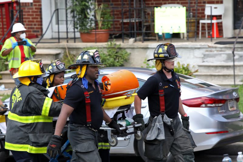 Fire fighters transport an injured person on a stretcher at the scene of an explosion in a residential area of Baltimore