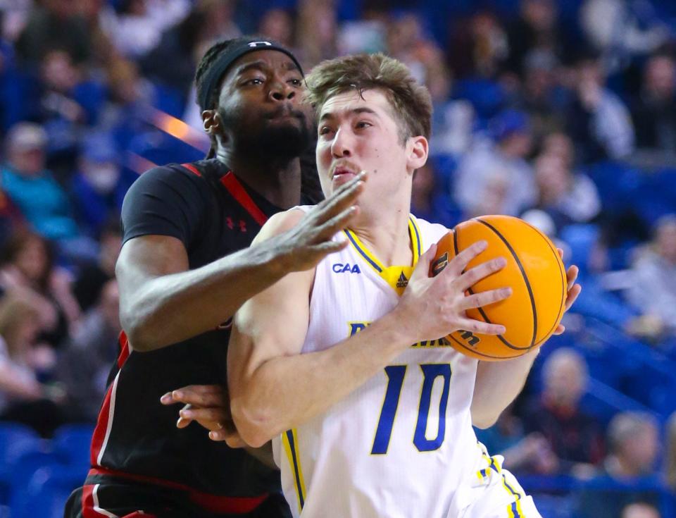 Delaware's Johnny McCoy (right) drives against Northeastern's Alexander Nwagha in the first half of Delaware's 81-78 win at the Bob Carpenter Center, Saturday, Jan. 28, 2023.